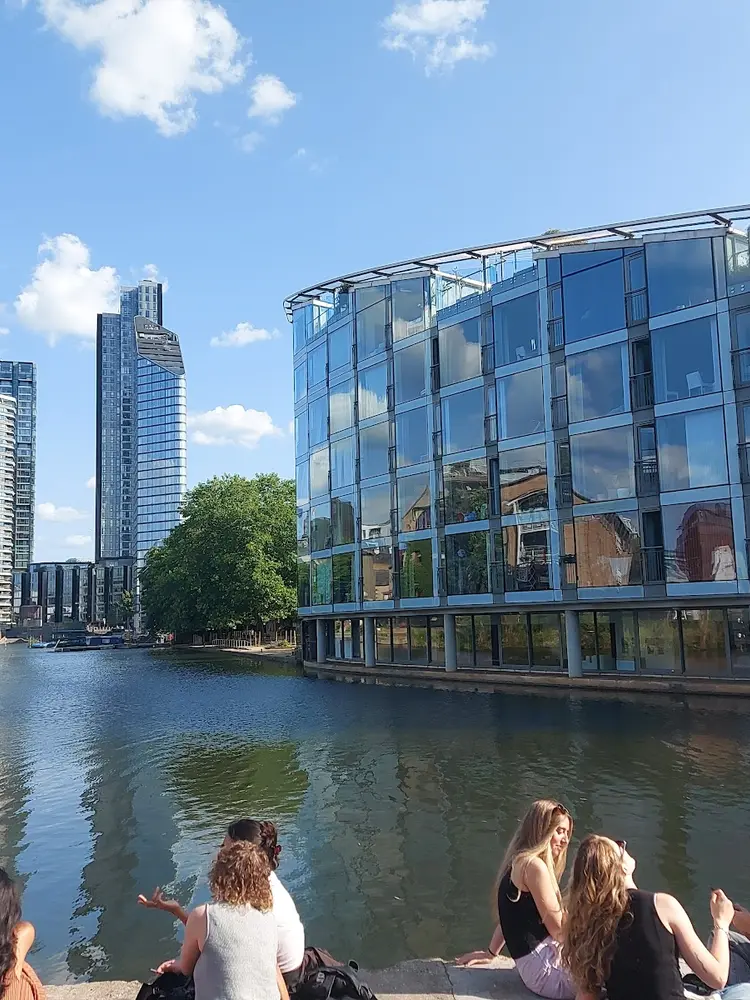 View across City Road Basin with a curved glass building on the right and towers in the distance